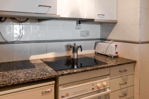 una cocina con cafetera en una encimera en Cau del Llop 76 apartamento piscina comunitaria en Girona
