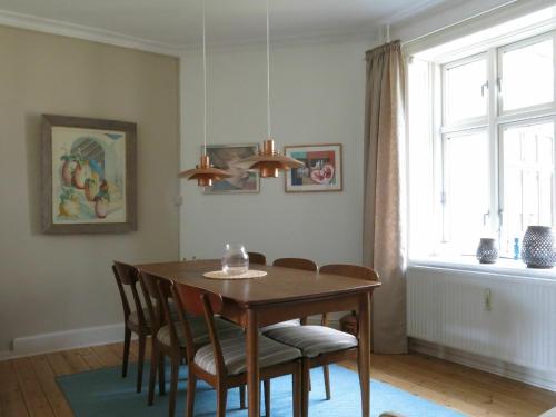 a dining room with a table and chairs and a window at ApartmentInCopenhagen Apartment 1170 in Copenhagen