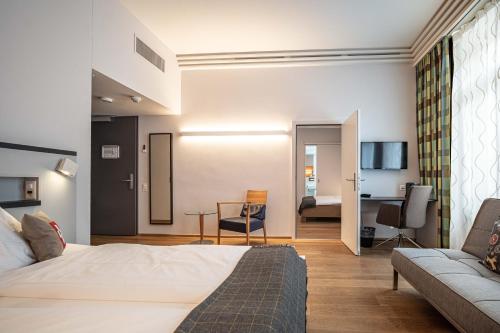 a hotel room with a bed and a couch at Hotel Bären am Bundesplatz in Bern