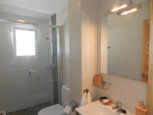 a bathroom with a sink and a shower with a mirror at Casa Zinat 4 PAX in Calpe