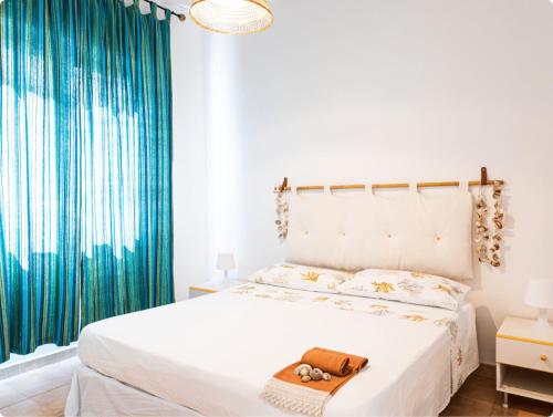 a bedroom with a white bed and blue curtains at Campitur in Campomarino