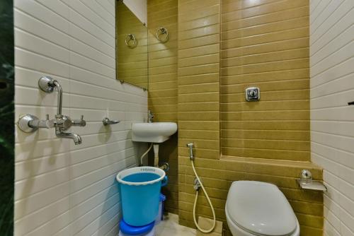 a small bathroom with a toilet and a sink at Hotel Guestinn Residency in Mumbai