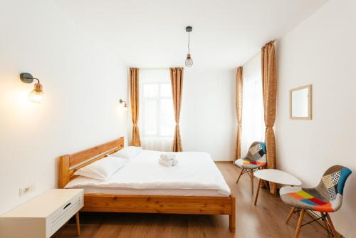 a bedroom with a bed and two chairs at Pensiunea Roua Apuseni Belis in Beliş
