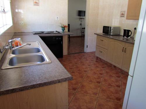 a kitchen with a sink and a counter top at Aruka in Bela-Bela
