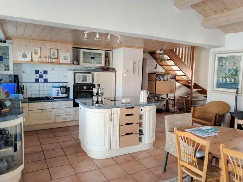a large kitchen with a table and a dining room at Maison pour 6 - Piscine - 750m de la plage in LʼÉpine