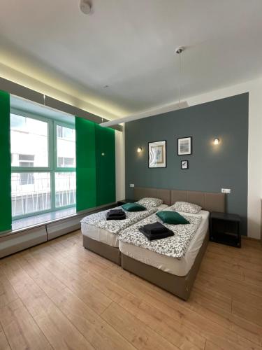 a bedroom with a large bed and a green wall at Dan In'n Out in Vienna