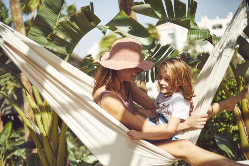 a woman and a little girl sitting in a hammock at Dreams Jardin Tropical Resort & Spa in Adeje