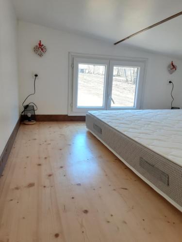 um quarto com uma cama grande e piso em madeira em Tiny des Rêves em Beulotte-Saint-Laurent