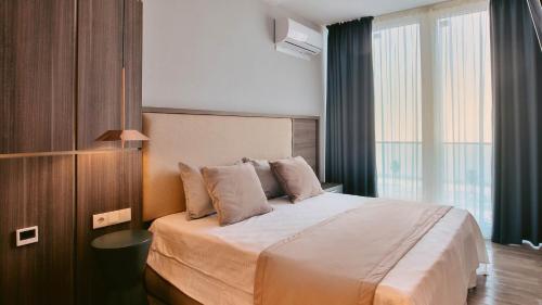 a bedroom with a large bed and a large window at Sunrise Residence in Batumi