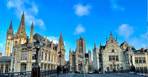 an old building with a clock tower and a cathedral at Heirloom Hotels - The Mansion in Ghent