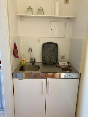 a small kitchen with a sink and a microwave at Jörg Christoph Paschke in Lübben