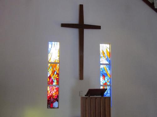 three stained glass windows in a church with a cross at Aruka in Bela-Bela