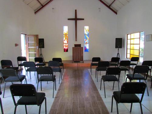 a room with chairs and a church with a cross at Aruka in Bela-Bela