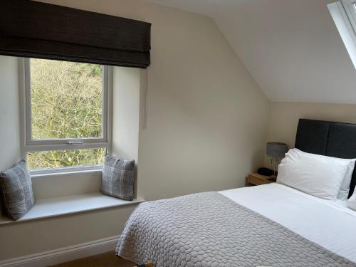 a bedroom with a bed and a window at Crow How Country Guest House in Ambleside