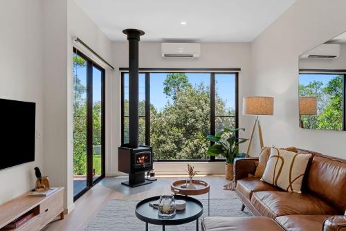 a living room with a couch and a stove at The Ridge at Maleny 1 Bedroom Villa with Spa in Maleny