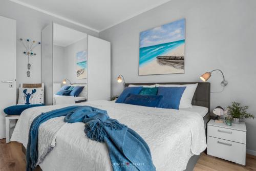 um quarto com uma cama com um cobertor azul em Ostsee - Appartement Nr 162 "Strandzeit" im Strand Resort em Heiligenhafen