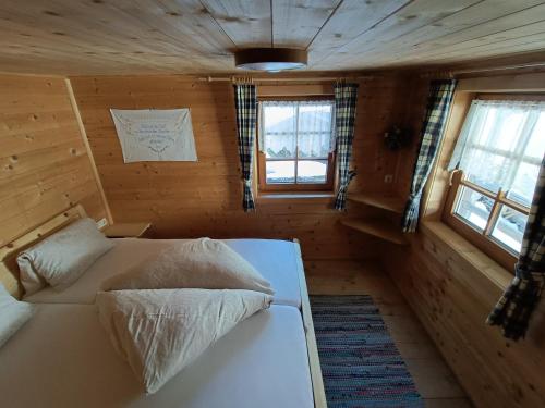 um quarto com uma cama num chalé de madeira em Urige Alm em Brandberg