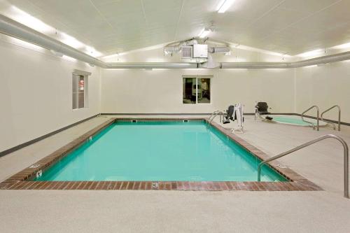 a large swimming pool in a room with a pool at Super 8 by Wyndham Belgrade/Bozeman Airport in Belgrade