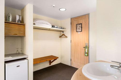 a bathroom with a sink and a wooden door at The Angus Hotel in Lower Hutt