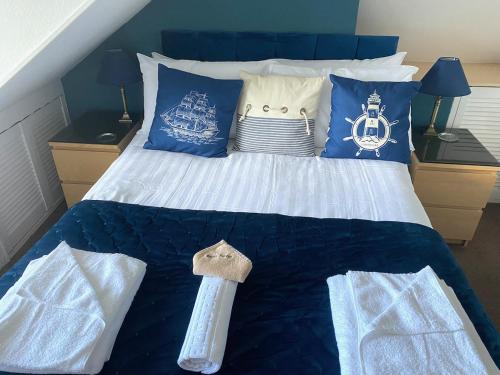 Una cama con almohadas azules y blancas. en The Ashleigh, en Paignton