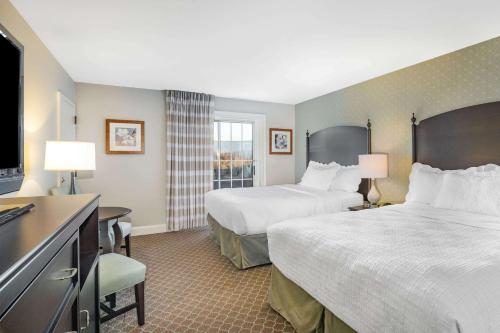 a hotel room with two beds and a flat screen tv at Natural Bridge Hotel, Trademark Collection by Wyndham in Natural Bridge