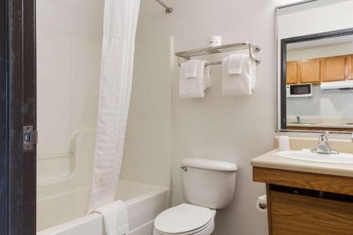 y baño con aseo blanco y lavamanos. en WoodSpring Suites Houston I-45 Airtex, en Houston