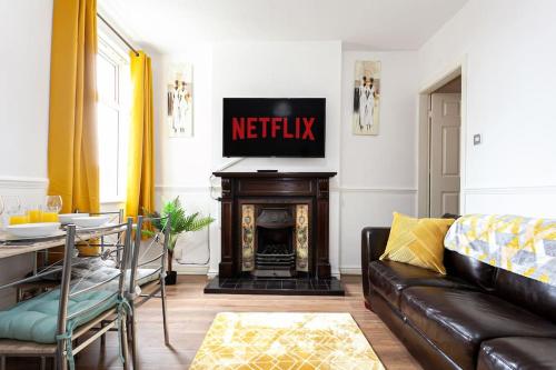 a living room with a couch and a fireplace at Fabulous Stay - 4 Bedroom House, sleeps 9, ideal for Business and Contractors, Free parking in Stoke on Trent