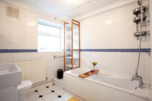 a bathroom with a tub and a toilet and a sink at Fabulous Stay - 4 Bedroom House, sleeps 9, ideal for Business and Contractors, Free parking in Stoke on Trent