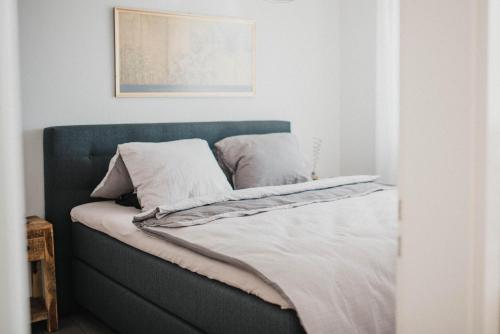 1 cama con cabecero azul y almohadas blancas en Ascona: Residenza Principessa Apt. 9, en Ascona