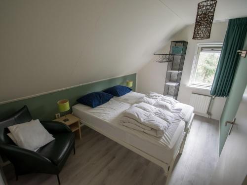 1 dormitorio pequeño con 1 cama y 1 silla en Cosy holiday home with terrace near natural park in Lemele, en Lemele