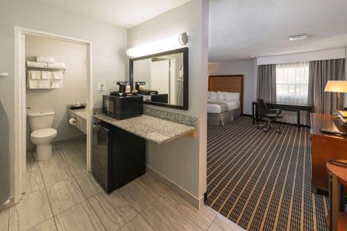 Habitación de hotel con baño con lavabo y aseo. en Clarion Pointe, en Medicine Hat