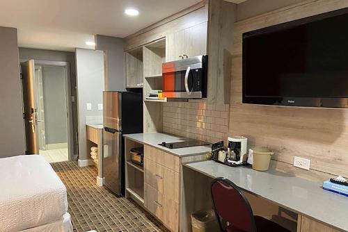 a hotel room with a kitchen with a bed and a kitchen at Ramada by Wyndham Medicine Hat in Medicine Hat