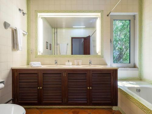 baño con lavabo y espejo grande en Penina Family House, en Portimão