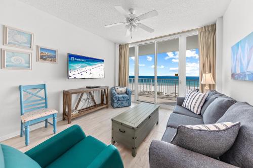 a living room with a blue couch and a view of the ocean at Lighthouse 307 in Gulf Shores