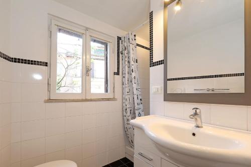 een witte badkamer met een wastafel en een raam bij Monserrato Apartment in Rome