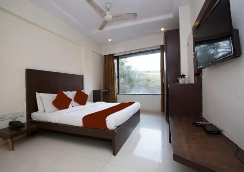 a bedroom with a bed and a flat screen tv at Hotel Kamran Residency-Near US Embassy in Mumbai