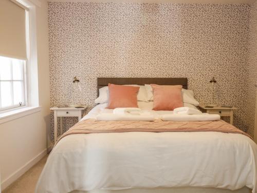 a bedroom with a large bed with floral wallpaper at The Toll House in Melrose