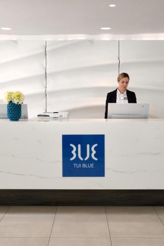 a man sitting at a desk with a laptop at TUI BLUE Adriatic Beach - Adults Only - All Inclusive in Igrane