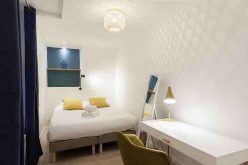 une chambre avec un lit, un bureau et des chaises dans l'établissement Le Nid du Lion - Joli T2 quartier St Georges au calme, à Lyon