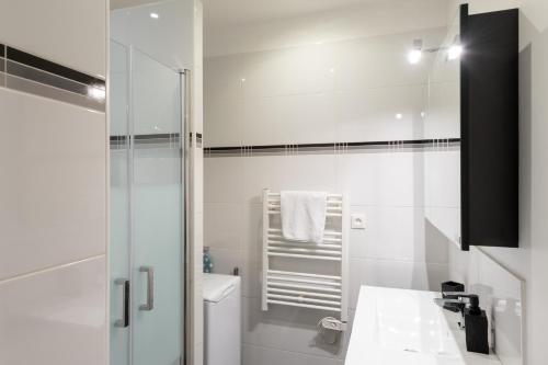 une salle de bain blanche avec un lavabo et des toilettes dans l'établissement Le Nid du Lion - Joli T2 quartier St Georges au calme, à Lyon