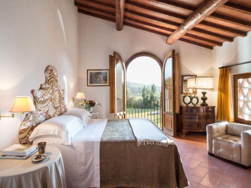 a bedroom with a large bed and a large window at Belvilla by OYO Villa Iole in Reggello