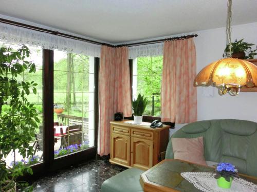 a living room with a green couch and a large window at Holiday home in Saxony with private terrace in Schlettau