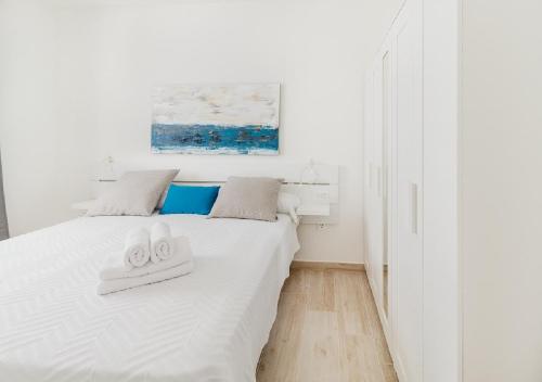 1 dormitorio blanco con 1 cama con 2 toallas en Moderno apartamento urbano en barrio histórico 1ºD, en Santa Cruz de Tenerife