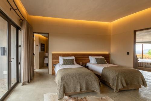 two beds in a room with a window at TimBila Private Villa in Omaruru