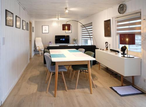 奧通的住宿－Chalet 2ch au bord de l’Ourthe，用餐室以及带桌椅的起居室。