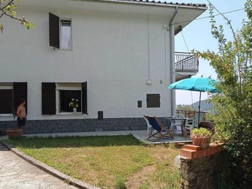 een wit huis met een tafel en een paraplu bij Belvilla by OYO Pizzamiglio in Moneglia