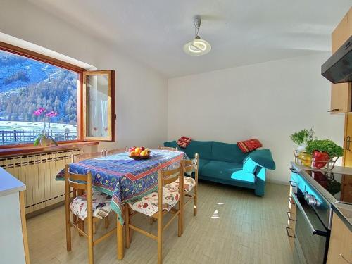 a living room with a table and a blue couch at La Maison De Chouflette in Cogne