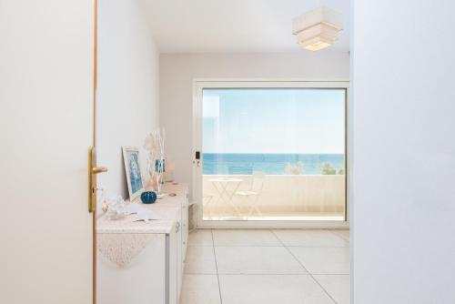 Habitación blanca con vistas al océano en Beach Studios con accesso diretto alla spiaggia, en Torre Pali