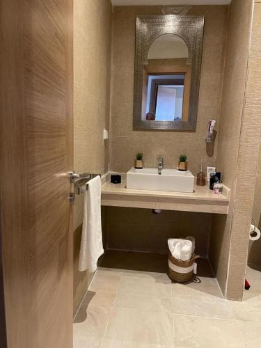 a bathroom with a sink and a mirror at La Perla de Marrakech Appart de Luxe in Marrakesh