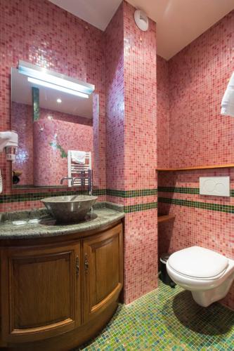 a bathroom with a sink and a toilet at Hôtel De Calais in Le Tréport